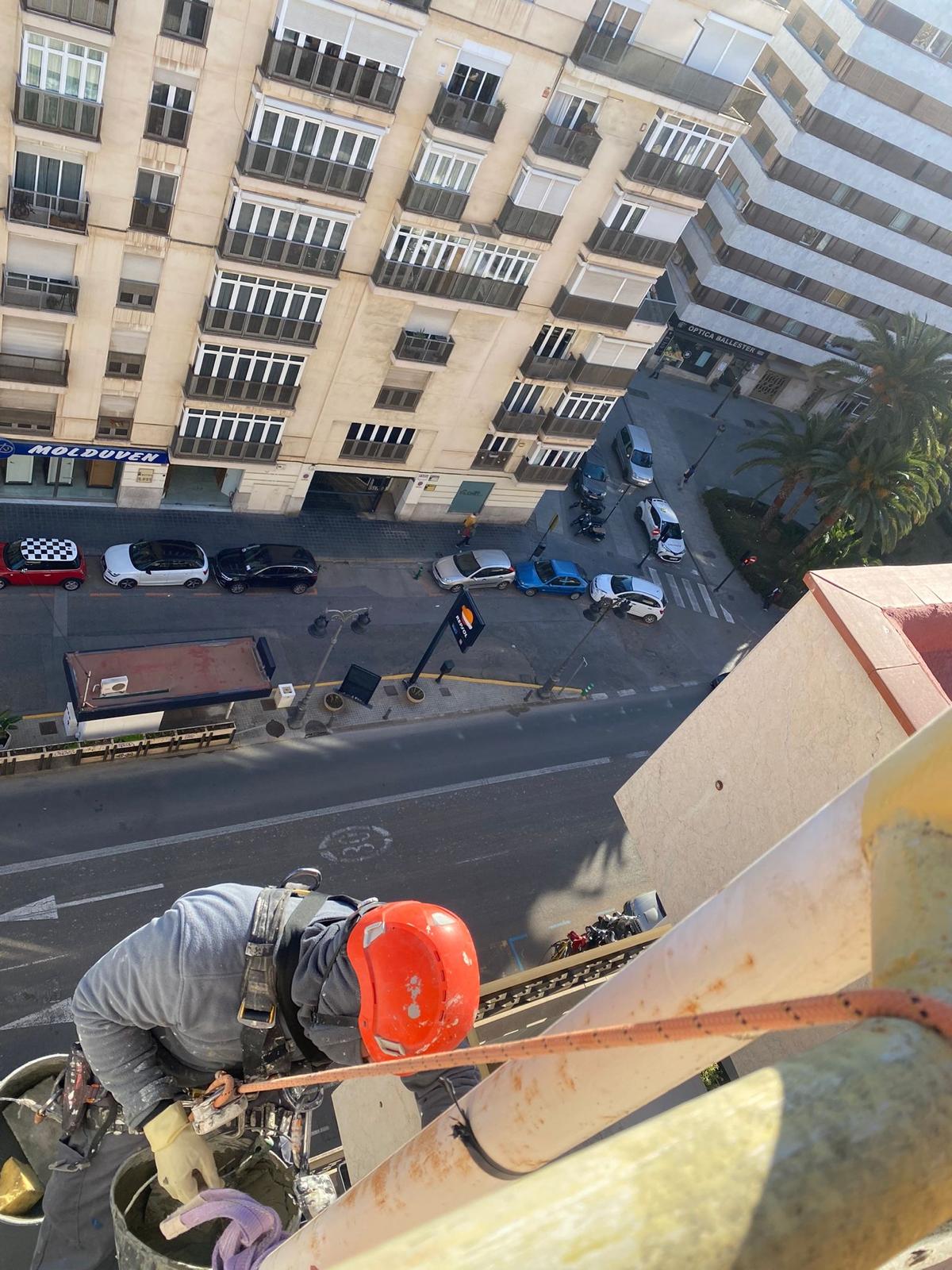 Operario realizando trabajos verticales en fachada de edificio en Valencia